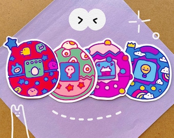 May include: Four colorful egg-shaped stickers with different designs. Each sticker features a cartoon-style illustration of a digital pet, including a green and yellow creature, a ghost, a pink and purple creature, and a blue creature with a hot air balloon.