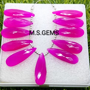 May include: A strand of pink chalcedony gemstone beads, each bead is faceted and shaped like a teardrop. The beads are strung on a silver chain with silver beads. The image includes the text "M.S. GEMS".