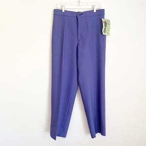 May include: Periwinkle-coloured trousers hanging on a white hanger. The trousers have a button closure and a straight leg design. A small tag is attached to the trousers.