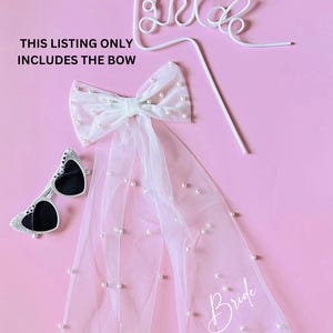 May include: White tulle veil with pearl embellishments and a white bow. The veil has the word "Bride" written on it. This listing only includes the bow.