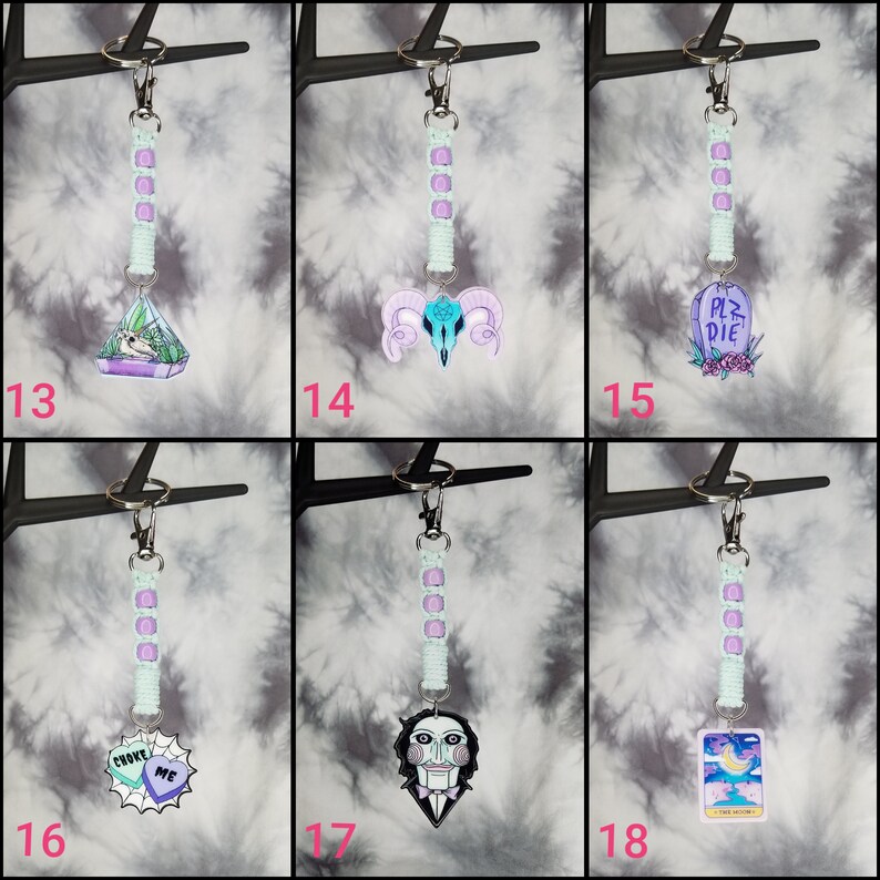 May include: Six different keychain charms with a pastel color scheme. The charms include a terrarium, a skull, a tombstone, a heart, a puppet, and a tarot card. Each charm is attached to a light green and purple beaded keychain.