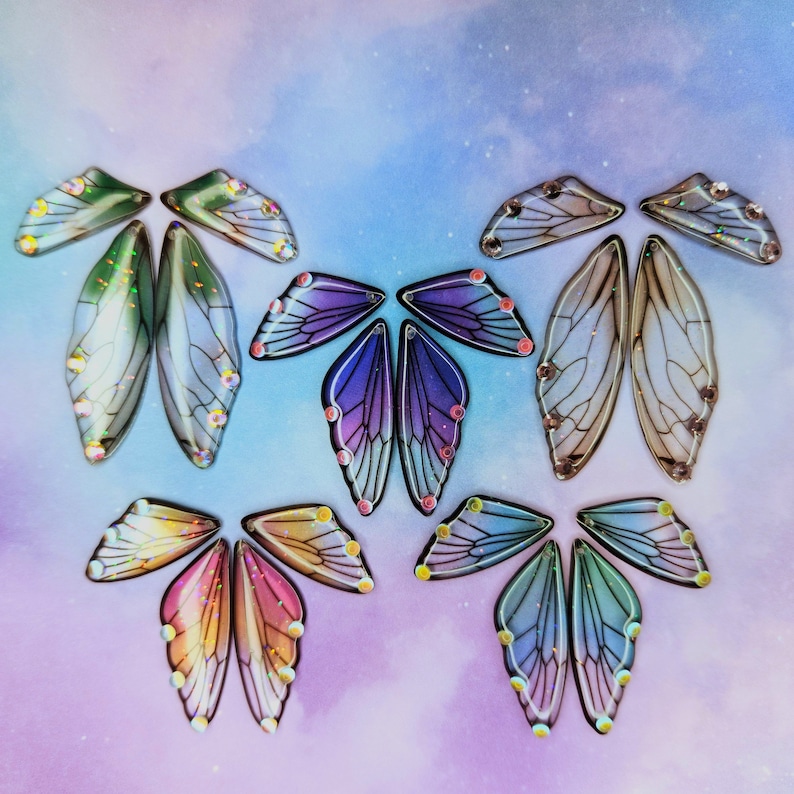 Puede incluir: Surtido de alas de mariposa iridiscentes con una variedad de colores y patrones. Las alas est&aacute;n hechas de un material transl&uacute;cido y tienen un aspecto delicado y et&eacute;reo.