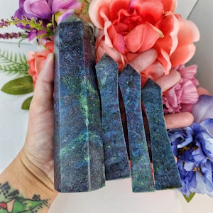 May include: Four dark blue and green crystal points with a marbled pattern. The points are arranged in a row, with the largest point in the center.