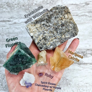 May include: A collection of crystals including green fluorite, franklinite with willie mite, cerussite, mariposa calcite, spirit flower chalcedony with purple fluorite, and ruby.
