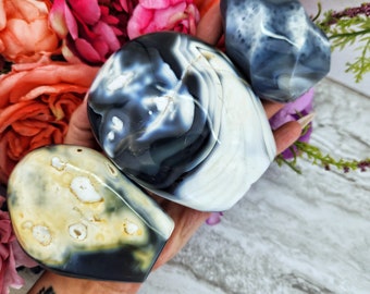 May include: Three agate stones, one with a white and black pattern, one with a white and yellow pattern, and one with a gray and white pattern.