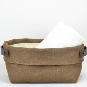 Natural Belgian bristol linen rectangular basket lined in organic cotton canvas. Detachable leather handles with button stud details. The cuff can be unrolled and extended.