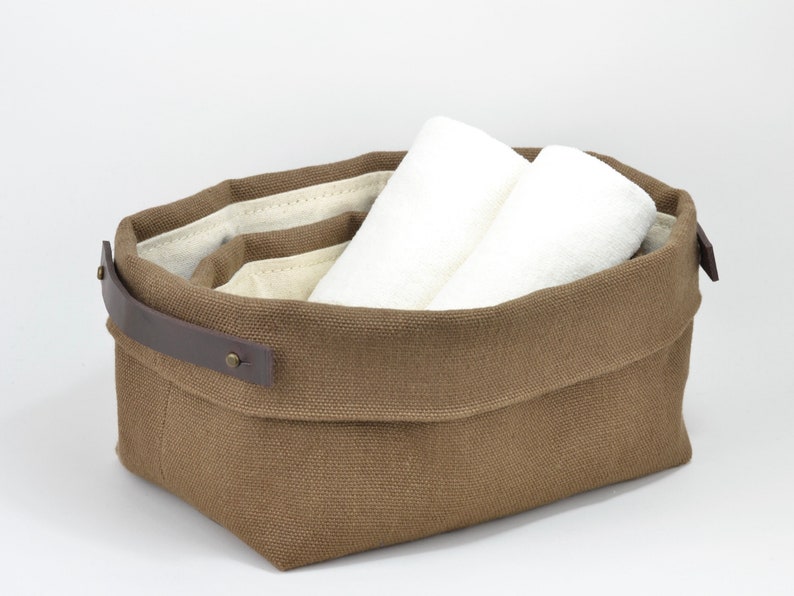 Natural Belgian bristol linen rectangular basket lined in organic cotton canvas. Detachable leather handles with button stud details. The cuff can be unrolled and extended.