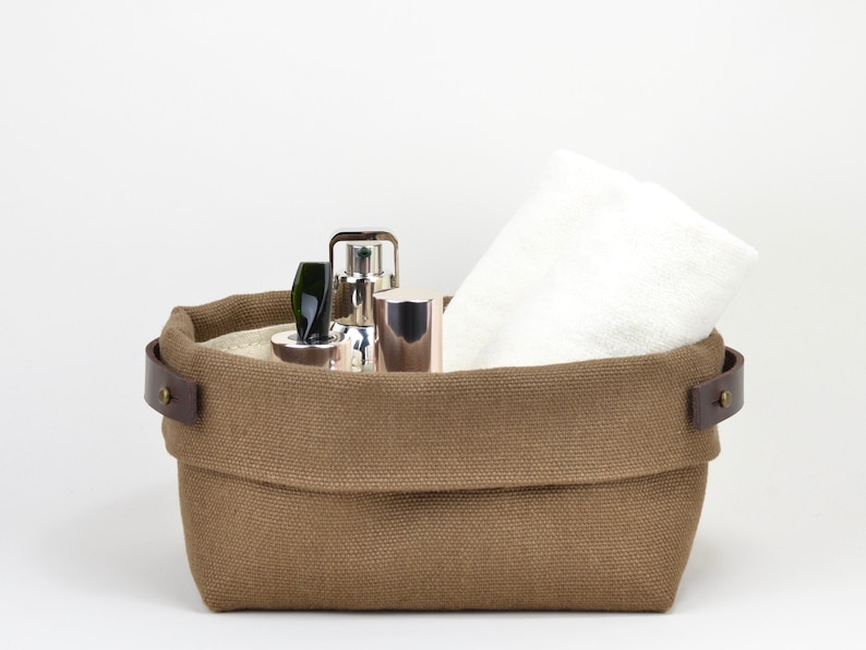 Natural Belgian bristol linen rectangular basket lined in organic cotton canvas. Detachable leather handles with button stud details. The cuff can be unrolled and extended.