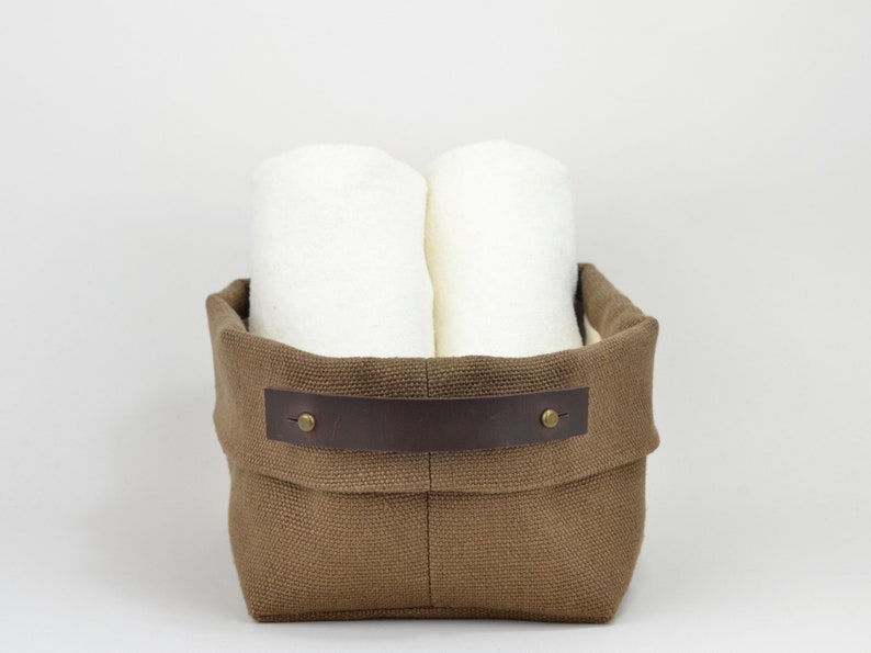 Natural Belgian bristol linen rectangular basket lined in organic cotton canvas. Detachable leather handles with button stud details. The cuff can be unrolled and extended.