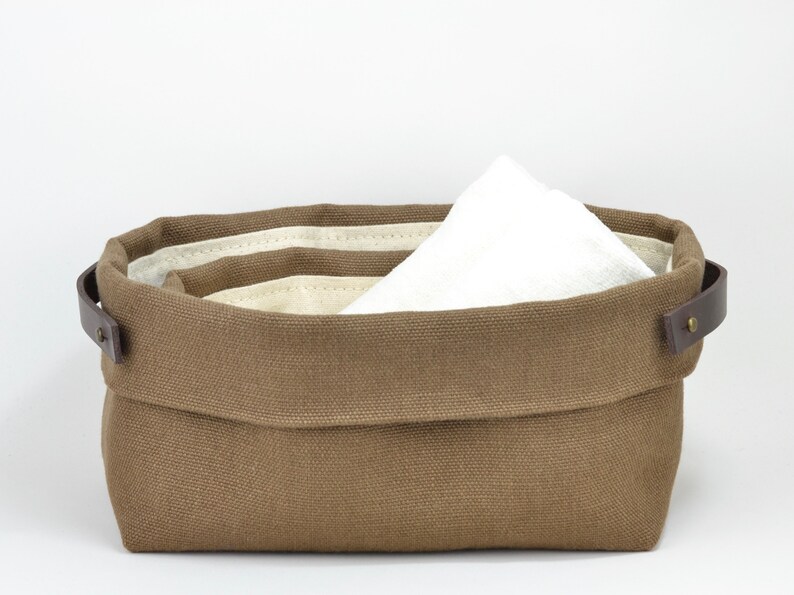 Natural Belgian bristol linen rectangular basket lined in organic cotton canvas. Detachable leather handles with button stud details. The cuff can be unrolled and extended.