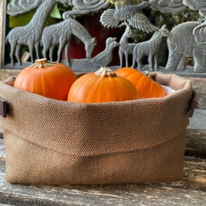 Natural Belgian bristol linen rectangular basket lined in organic cotton canvas. Detachable leather handles with button stud details. The cuff can be unrolled and extended.