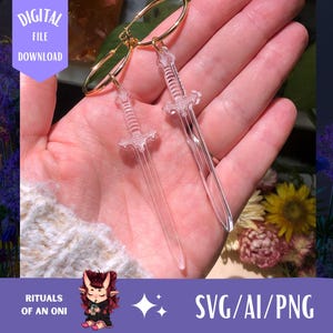 Puede incluir: Pendientes de espada de acrílico transparente con aros dorados. Los pendientes se sostienen en una mano, con un fondo borroso de flores y el texto "DIGITAL FILE DOWNLOAD" y "SVG/AI/PNG".