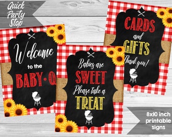 May include: Three printable signs with a red and white gingham background. The signs feature black chalkboard text with yellow accents. The text on the signs reads "Welcome to the Baby-Q", "Babies are Sweet Please take a Treat", and "Cards and Gifts Thank you!"