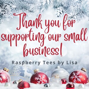 May include: Thank you for supporting our small business! Raspberry Tees by Lisa. A wintery scene with red and silver ornaments on a snowy surface.