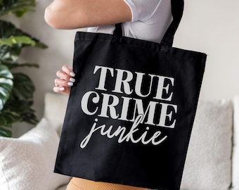 May include: Black canvas tote bag with white text that reads "TRUE CRIME junkie".