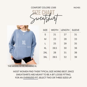 May include: A light blue Comfort Colors sweatshirt with a size chart. The chart lists sizes S to 3XL, with measurements in inches for width, length, and sleeve. The model is 5'8 and wearing XL. Text on the image says "Sweatshirt".