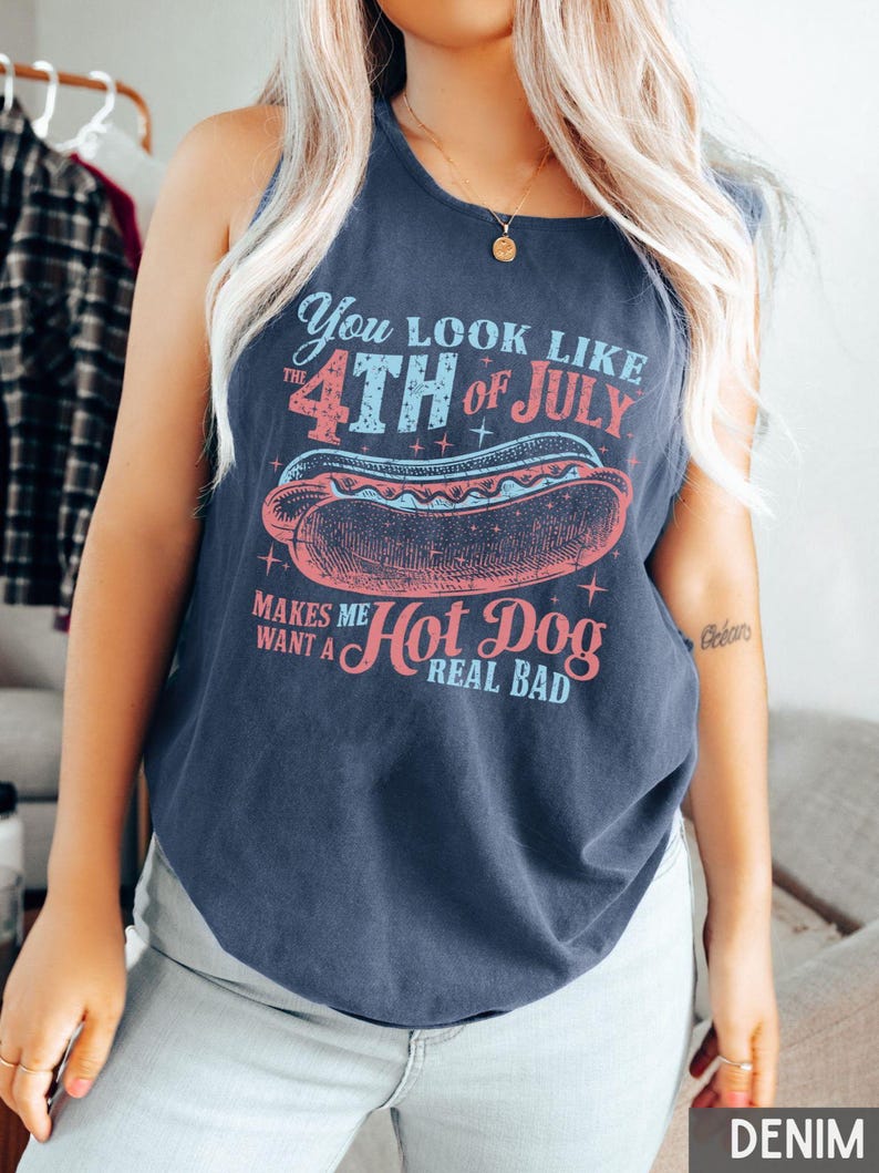 Puede incluir: Una camiseta sin mangas azul marino con el texto "You look like the 4th of July makes me want a hot dog real bad" y un gr&aacute;fico de un perrito caliente. El texto y el gr&aacute;fico son en rojo, azul y rosa.