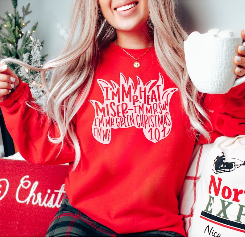May include: Red sweatshirt with white text that reads "I'm Mr. Heat Miser - I'm Mr. Sun - I'm Mr. Green Christmas 101".