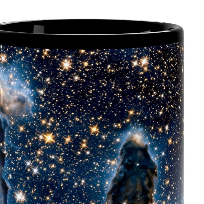 May include: A black coffee mug with a colorful image of a nebula with stars and gas clouds. The mug is a standard size and shape.