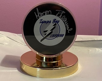 Tampa Bay Lightning puck, signed by MANON RHEAUME !! The FIRST woman to play in an N H L Game !!