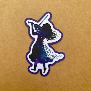 May include: Silhouette of a person playing a violin with a galaxy-like pattern and musical notes on their dress. The background is a brown surface.