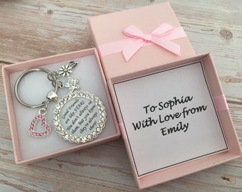 May include: A silver keychain with a heart charm and a circular charm with the text "Good Friends are like STARS". The keychain is in a pink gift box with a pink bow and the text "To Sophia With Love from Emily".
