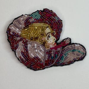 beaded girl in flower brooch