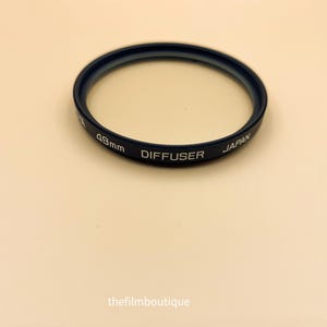 May include: A black 49mm lens diffuser filter with the text "DIFFUSER JAPAN" printed on it.
