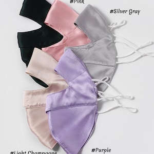 May include: Five satin face masks in different colors: black, pink, silver gray, light champagne, and purple. Each mask has a unique color and is made of soft, silky fabric.