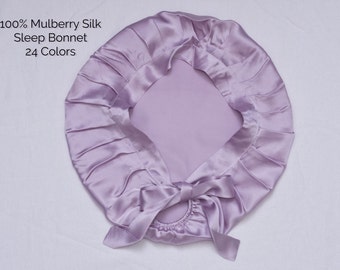 Op de afbeelding: Een lavendelkleurige slaapmuts van zijde met een strik. 100% Mulberry Silk Sleep Bonnet 24 kleuren.