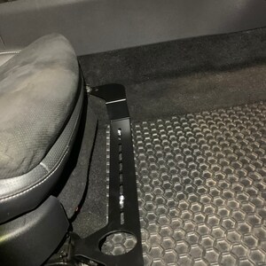 Nissan GTR R35 fire extinguisher holder bracket mounted on OEM seat rails. Ensure safety with this easy-to-access and sturdy bracket for emergencies. Perfect fit for your GTR R35