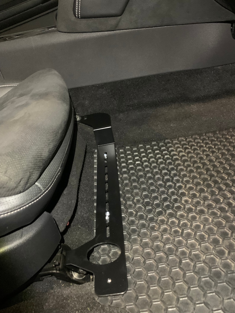 Nissan GTR R35 fire extinguisher holder bracket mounted on OEM seat rails. Ensure safety with this easy-to-access and sturdy bracket for emergencies. Perfect fit for your GTR R35