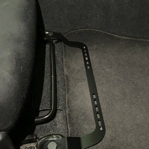 Toyota GT86 fire extinguisher holder bracket mounted on OEM seat rails. Ensure safety with easy access to the fire extinguisher while driving. A reliable addition to your GT86 for emergency situations