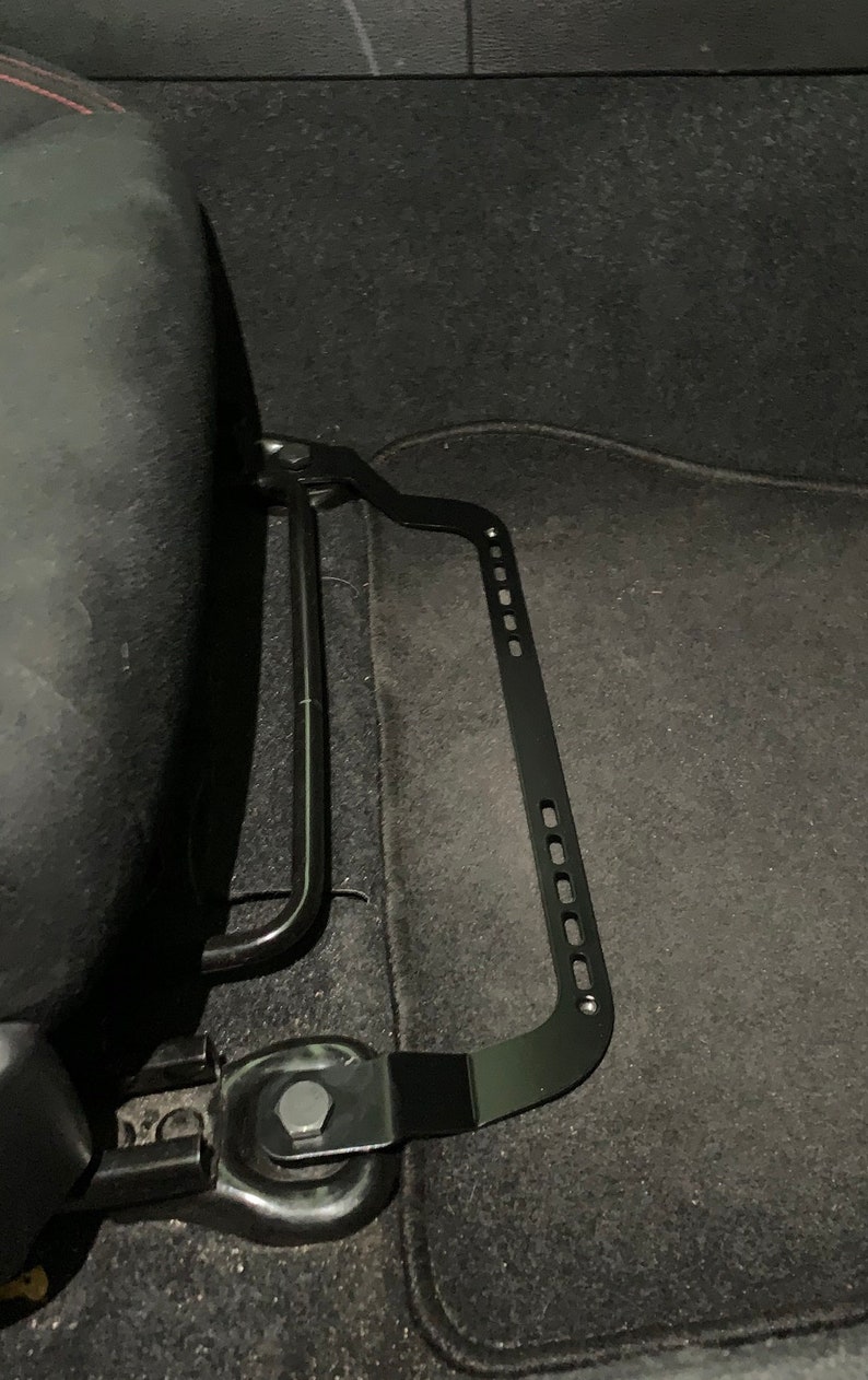 Toyota GT86 fire extinguisher holder bracket mounted on OEM seat rails. Ensure safety with easy access to the fire extinguisher while driving. A reliable addition to your GT86 for emergency situations