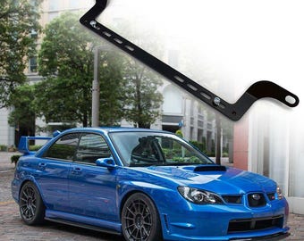 May include: A black metal bracket for mounting a light bar or other accessories to a car. The bracket is shown mounted to a blue Subaru Impreza.