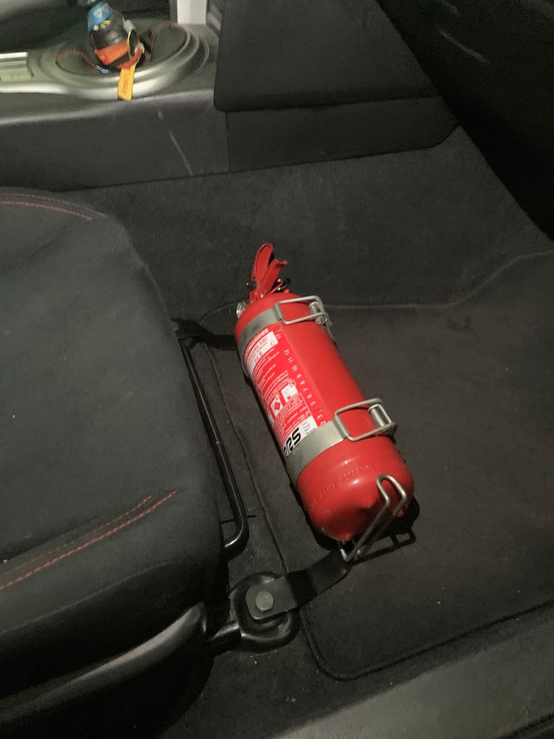 Toyota GT86 fire extinguisher holder bracket mounted on OEM seat rails. Ensure safety with easy access to the fire extinguisher while driving. A reliable addition to your GT86 for emergency situations
