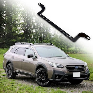 Pode incluir: Um acessório de carro de metal preto é exibido acima de um SUV marrom. O acessório tem um design curvo com vários orifícios e pontos de montagem. O SUV tem rodas pretas e uma grade dianteira preta.