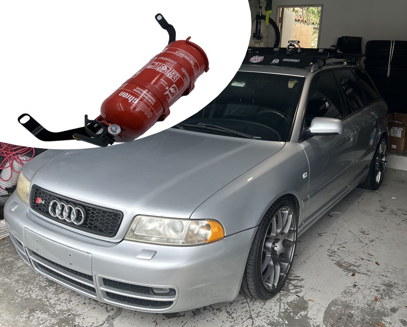 May include: A silver Audi S4 with a black grille and a fire extinguisher mounted on the front bumper.