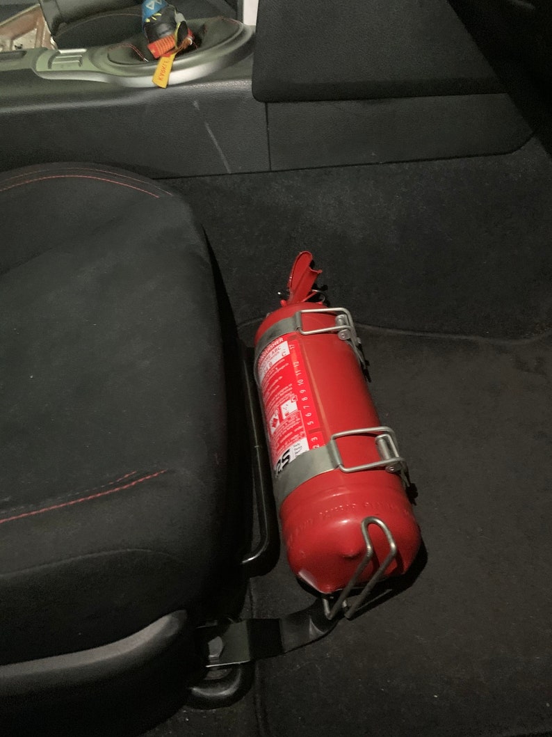 Toyota GT86 fire extinguisher holder bracket mounted on OEM seat rails. Ensure safety with easy access to the fire extinguisher while driving. A reliable addition to your GT86 for emergency situations