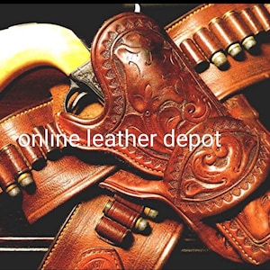 Puede incluir: Una funda de cuero marrón con tallas intrincadas y una pistola plateada con mango blanco. La funda tiene un lazo para el cinturón y un lazo para balas. El texto "online leather depot" es visible en la funda.