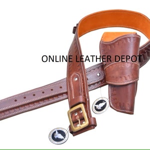 Pode incluir: Um cinto de pistola de couro castanho com uma coldre e um cinto de cartuchos. O cinto é decorado com costuras e tem uma fivela de latão. A coldre também é decorada com costuras e tem uma aba.