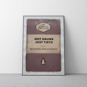 Könnte beinhalten: Ein Buchcover mit braunem Hintergrund und einer Pinguin-Illustration. Der Titel lautet "Not Drunk Just Tipsy" und der Untertitel lautet "Modern Philosophy".