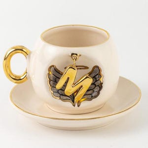 Taza con letras personalizadas y detalles en oro real de 24 quilates, hecha a mano, de cerámica para té, café y espresso, con alas de ángel y halo.