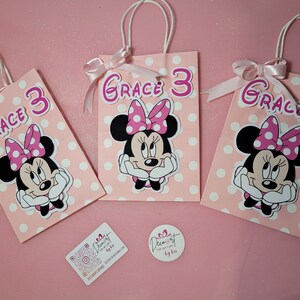 May include: Three pink and white polka dot gift bags with Minnie Mouse character and the name "Grace 3" on each bag.