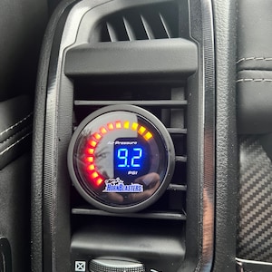 Könnte beinhalten: Ein schwarzes Messgerät mit einem roten und gelben LED-Ring zeigt "9,2 PSI" für den Luftdruck an. Das Messgerät ist mit "Luftdruck" und "HornBlasters" beschriftet.