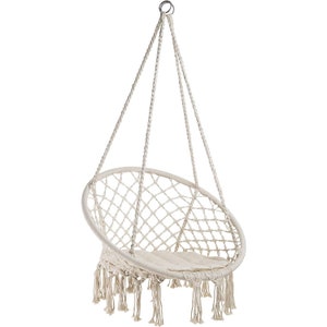 Puede incluir: Una silla colgante blanca con un asiento redondo tejido y detalles de flecos. La silla est&aacute; suspendida de un gancho de metal.