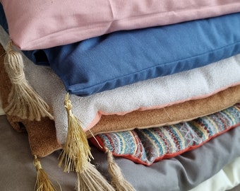 May include: A stack of colorful cushions with tassels. The cushions are made of different fabrics and have a variety of patterns.