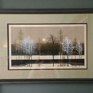 Könnte beinhalten: Gerahmter Kunstdruck mit einer ruhigen Waldszene mit Bäumen in Weiß, Braun und Schwarz. Ein Vollmond ist am Himmel zu sehen. Das Kunstwerk ist in einem dunkelgrauen Rahmen gerahmt.