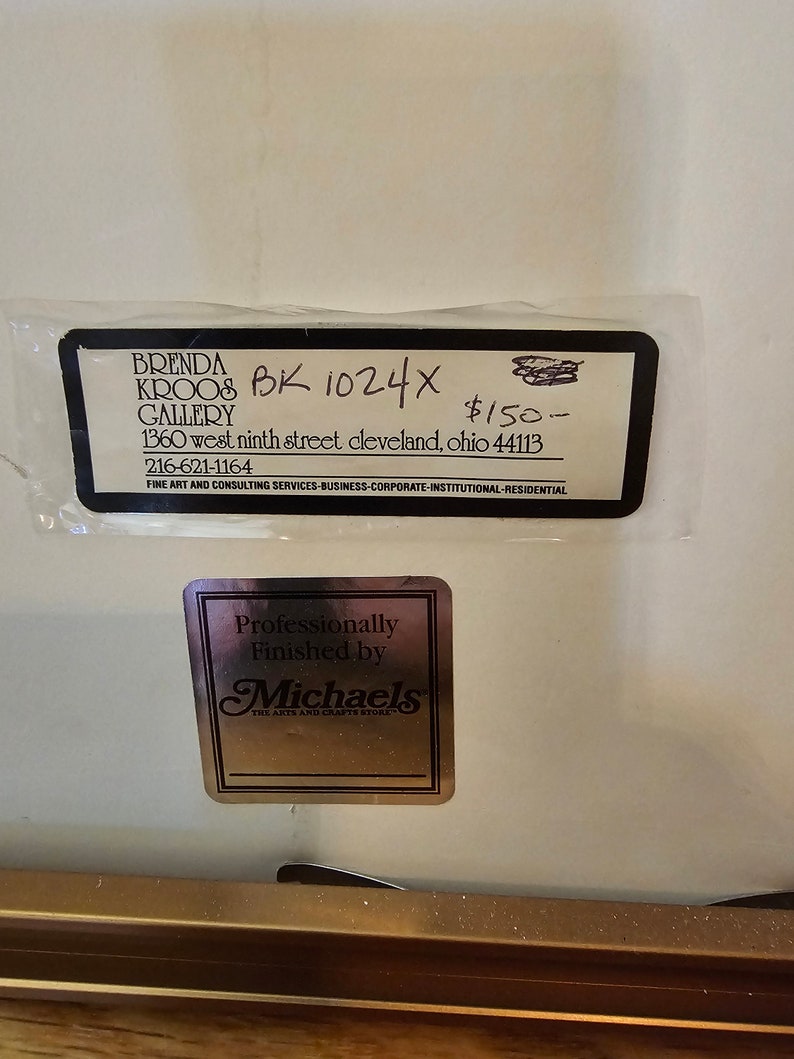 May include: A black and white sign with the text "BRENDA KROOB GALLERY" and "BK 1024X $150." The sign also includes the address "1360 west ninth street cleveland, ohio 44113" and the phone number "216-621-1164". The sign also includes the text "FINE ART AND CONSULTING SERVICES-BUSINESS-CORPORATE-INSTITUTIONAL-RESIDENTIAL".
