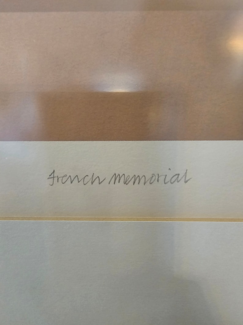 May include: A close-up of a white card with the text "French Memorial" written in black ink.